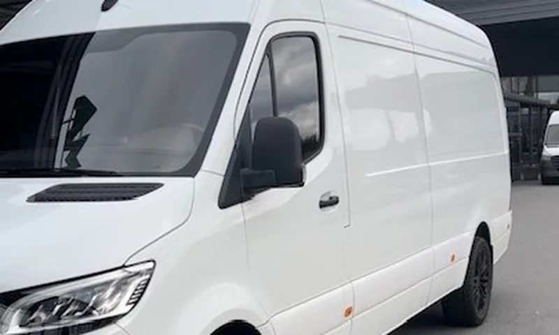 Valkoinen pakettiauto kuljetusajossa